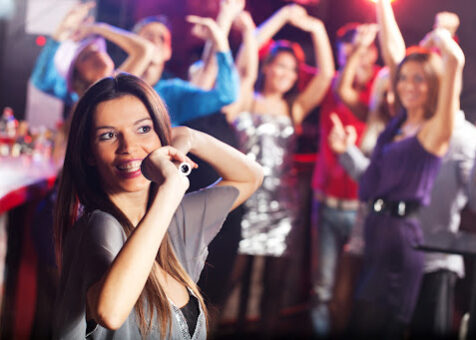 Young woman singing in a discotheque. She is looking at the distance.